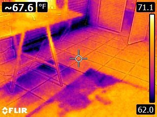FLIR thermal camera image showing cold wet areas spreading across a tiled floor